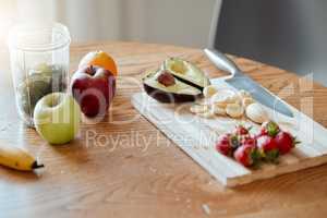 Cooking, preparing and making fruit smoothie, drink and salad in home kitchen for healthy breakfast, meal and snack. Closeup of apples, strawberries and avocado with banana for vitamins and nutrition
