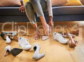 So many to choose from. an unrecognizable womans feet seen trying on a wide variety of womans shoes on the floor at home.