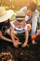 more than a seed is planted in a garden. a family gardening together in their backyard.