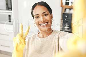Peace sign, clean and hygienic domestic taking a selfie with a hand gesture at home. Carefree woman enjoying good hygiene while cleaning, doing chores and housework alone expressing happiness.