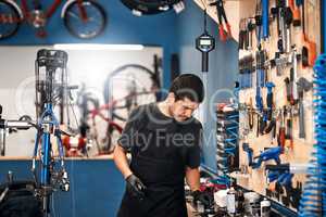 Giving second hand bikes a second chance. a man working in a bicycle repair shop.