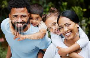 Happy, smiling and loving family bonding enjoying fun moments together in the outdoors. Portrait of playful, joyful and caring parents having quality time and giving kids a piggyback ride in nature