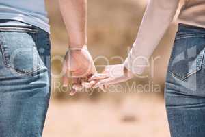 Affectionate couple holding hands showing love, caring and bonding outside together in nature. Loving boyfriend and girlfriend expressing unity, understanding and trust in their relationship