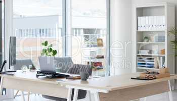 Clean, bright and empty home office interior organized with a computer and desk inside. Modern, contemporary and work space view of a decorated room with stylish decor and wooden furniture indoors