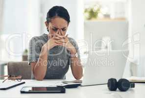 Stress, anxiety and worry with a businesswoman feeling negative, overworked and overwhelmed while suffering from a headache or migraine. Young female working on a laptop at her desk in the office