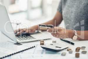 Budget with technology for online shopping and working indoors. Closeup of financial advisor counting money on laptop in the office. Businesswoman holding card, coins and calculator on table.