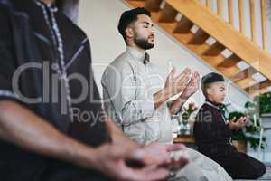 Muslim family praying together at home with eyes closed during fajr, dhuhr, asr, maghrib or Isha. Practicing religion and cultural tradition to serve or worship the god of their faith and belief