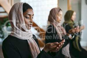 Praying, muslim and young women group practicing arabic, holy and islamic religion indoors. Females wearing a hijab while kneeling to practice a quiet, spiritual and worship prayer inside in silence