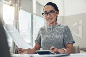 Home budget, finances and bills being calculated by a young woman sitting at home. Young female calculating her expenses, debt and spendings while doing monthly tax returns or planning in the lounge