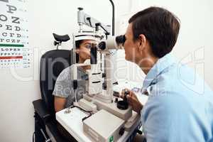 Eye and vision test, exam or screening with an optometrist, optician or ophthalmologist and a patient using an ophthalmoscope. Testing and checking eyesight for prescription glasses or contact lenses