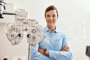 Confident, happy and proud optometrist standing with arms crossed, ready for checkup and preparing equipment in an optometry office. Smiling, successful and wellness portrait of an ophthalmologist
