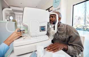 Eye test, exam or screening with a young man at the optometrist using an automated refractor. Patient testing his vision and eyesight with an optician for prescription glasses or contact lenses