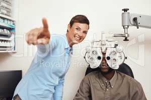 Happy optometrist doing eye test on a patient, examining vision and doing optical exercise at an optometry checkup. Young black man consulting with an opthalmologist, measuring and checking eyesight