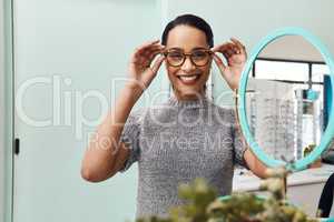 Woman wearing pair of trendy glasses, stylish spectacles and new prescription lenses at an optometrist. Portrait of a customer choosing, buying and shopping for frames for better vision and eyesight