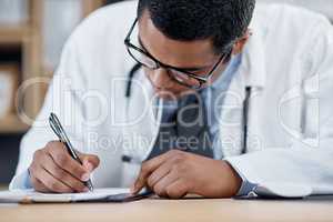 Doctor writing a prescription, survey or medical care paperwork for a patient at the hospital. A healthcare professional writing a patient information chart. A GP filing a document in an office