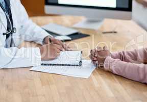 Doctor writing a prescription on paper for a patient at the hospital. Closeup of the hands of a healthcare professional drafting a medical letter or form. A GP filing a document in an office