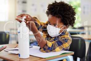 Student applying sanitizer in school class for hygiene, clean hands and to protect from spread of covid and cold germ. Afro child or little boy learning and getting education in corona virus pandemic