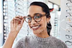 Woman wearing pair of trendy glasses, stylish spectacles and new prescription lenses at an optometrist. Portrait of a customer choosing, buying and shopping for frames for better vision and eyesight