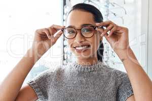 Glasses, vision and treatment by satisfied woman at optometrist, smiling and confident. Portrait of carefree female buying trendy spectacles to help with blurry vision, excited about her eyeglasses