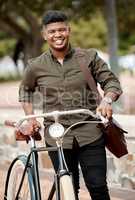 Happy business man riding a bicycle, commuting and staying active while traveling in city. Portrait of a smiling, cheerful and positive guy cycling on a bike and being carbon neutral at a park