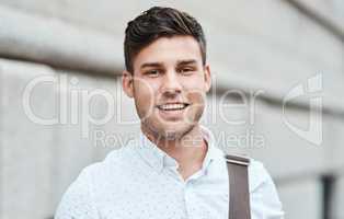 Face of a happy, smiling and professional business man, entrepreneur or employee standing in the city. Portrait headshot of a charming male businessperson or guy looking confident in an urban town