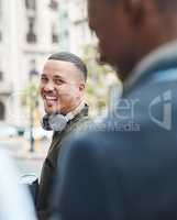 Real life young man portrait in the street with headphones, enjoying music on a playlist app looking happy, stressless and cool. Normal face of a millennial with wireless tech outside an urban city