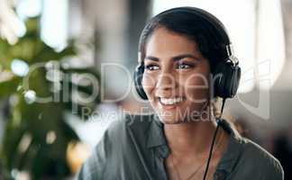 Happy face of young woman listening to music on headphones, happy and relaxed at home. Female smiling while spending her free time enjoying an audio book or learning a new language on the weekend