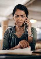 Young and confused business owner on the phone making a stock order for her cafe, restaurant or coffee shop. A female employee, manager or store owner looking at a book of products or inventory.
