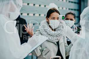 Health care worker scanning a frustrated woman temperature for corona with a thermometer. Concerned female made victim of racial profiling, looking annoyed and angry during the pandemic