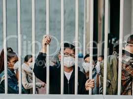 Behind bars, lockdown and covid restrictions with a man wearing a mask during a pandemic and travel ban. Portrait of a male being locked out during the international or global corona virus outbreak