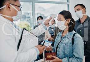 Travel restriction, covid pandemic and temperature check at airport. Asian female wearing mask for corona virus prevention waiting in departure inspection line, doctor pointing digital thermometer.