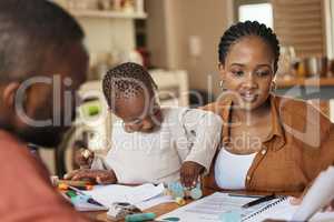 Busy, tired and multitask mother working while taking care of her child at home. African american entrepreneur or freelancer analyzing paperwork with her husband while holding her busy and cute son