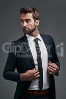 The main mission on his mind is success. Studio shot of a handsome young businessman posing against a grey background.