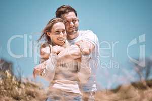 In love, hugging and relaxing young couple happy, smiling on an outdoors vacation getaway. Romantic couple relax outside together embracing and loving romance, happiness and the sun on a summer day