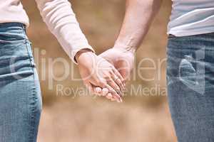 Couple holding hands, love and care showing affection, friendship and romance while on a walk together in nature. Closeup of boyfriend and girlfriend expressing loving, caring and comforting emotion
