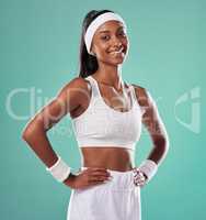 Happy, confident and smiling tennis player in sports uniform and hands on hips while ready to play with positive attitude. Fit and sporty female standing against a studio background with copy space