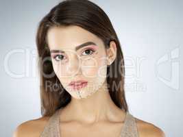Enhancing her features. Studio shot of a beautiful young woman posing against a gray background.