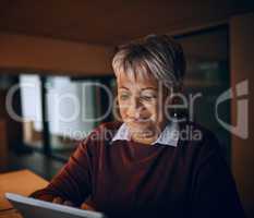 Night time business browsing. a mature businesswoman using a digital tablet while working late in an office.