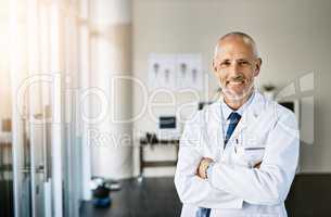 Call on me to care for your health. Portrait of a mature doctor standing in a hospital.