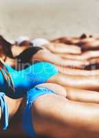 Its summer and all beach bums are invited. a group of young women relaxing together on the sand at the beach.