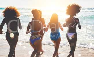 Summers here, lets get salty. a group of happy young women having fun together at the beach.