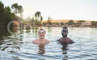 Vacation, friends and having fun while swimming in a lake and enjoying summer. Portrait of happy and diverse guys smiling while enjoying the water and friendship on their holiday and nature travel