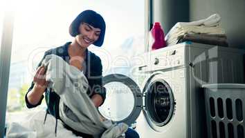 I got that stain out. a young woman doing her laundry at home.