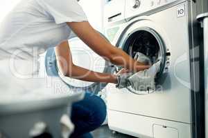 Laundry day comes around once every week. a young woman doing her laundry at home.