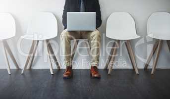 Connected in the lobby. Studio shot of an unrecognizable businessman waiting in line against a white background.