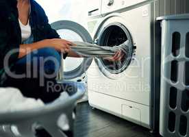 Time to get this dried. a young woman doing her laundry at home.