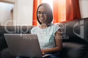 Enjoying some social networking the weekend. an attractive young woman using a laptop at home.