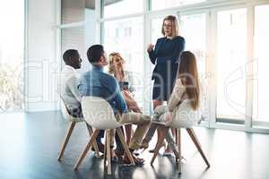 Im open to suggestions. Full length shot of a young businesswoman addressing her colleagues during a meeting in the office.