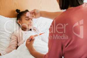 Covid, care and sick little girl in bed with concerned mother checking temperature with a thermometer. Caring parent worried about her child with a fever, suffering from a cold, flu and covid fatigue
