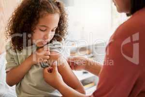 Covid nurse vaccinating child putting a bandage on at a clinic. Doctor applying plaster on girl after an injection at health centre. Pediatric, immunity and prevention at medical childrens hospital